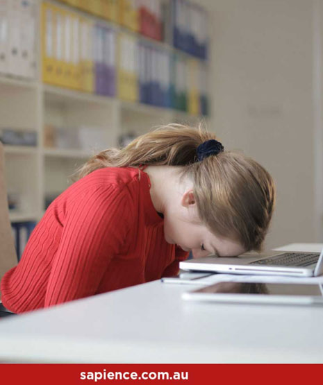 exhausted lady with forehead resting on laptop keyboard