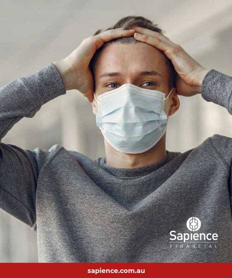 male with surgical face mask holding his head