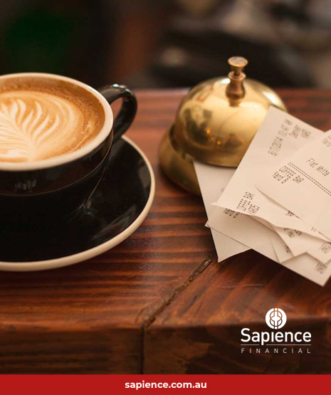 cup of coffee beside a stack of receipts