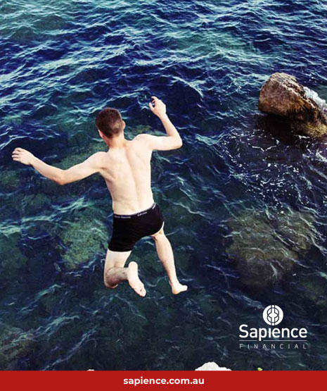 man jumping into deep water with rocks nearby