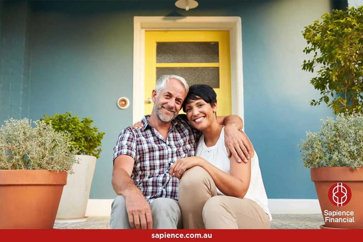 middle aged husband and wife sitting in front step of their home