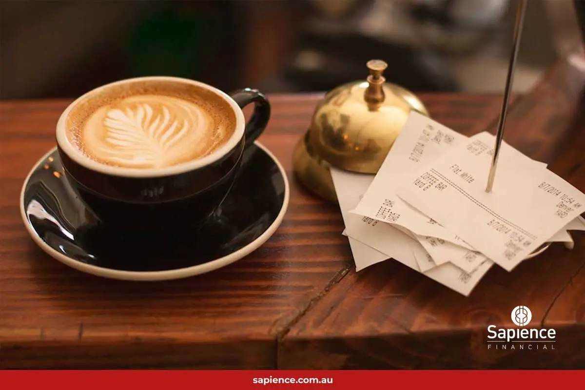cup of coffee beside a stack of receipts