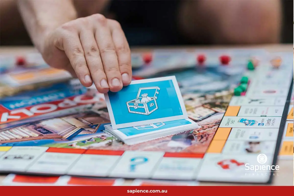 person selecting the unknown Community Chest card in the board game Monopoly 